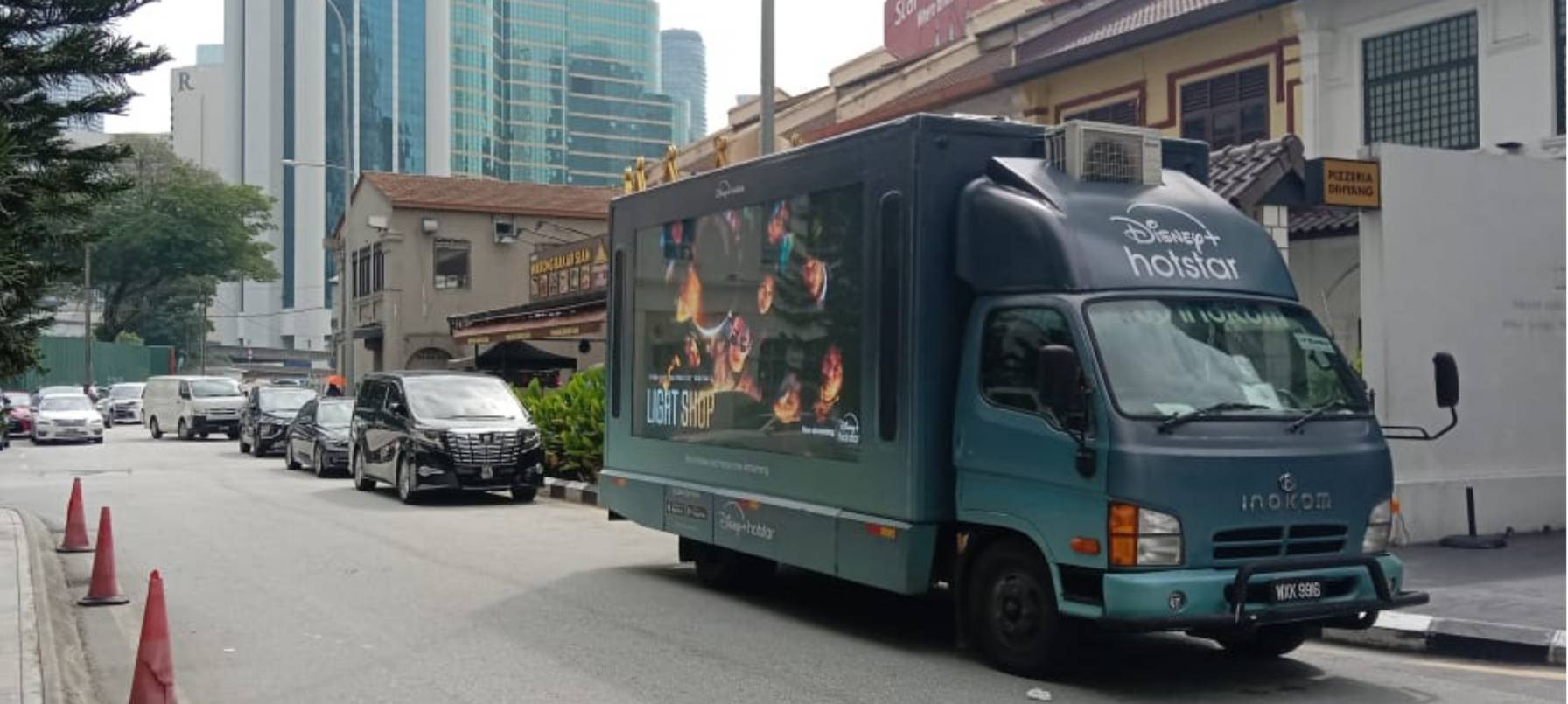 Brightly lit digital advertising truck providing information at a public spot
