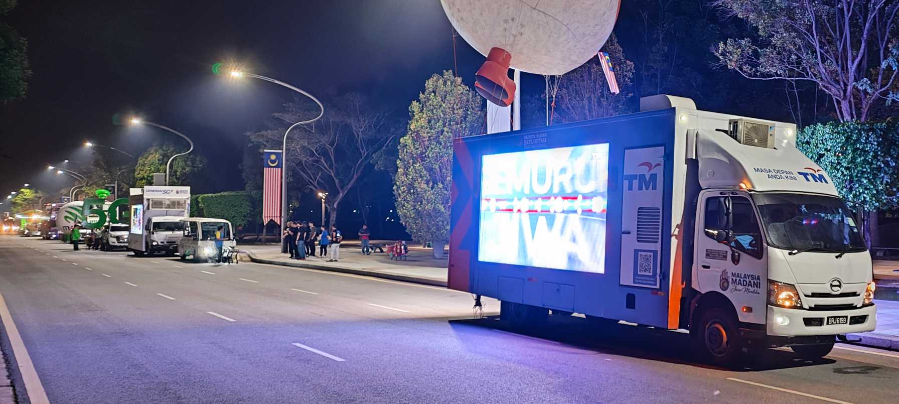 Telekom Malaysia colorful digital advertising truck attracting crowds at a street